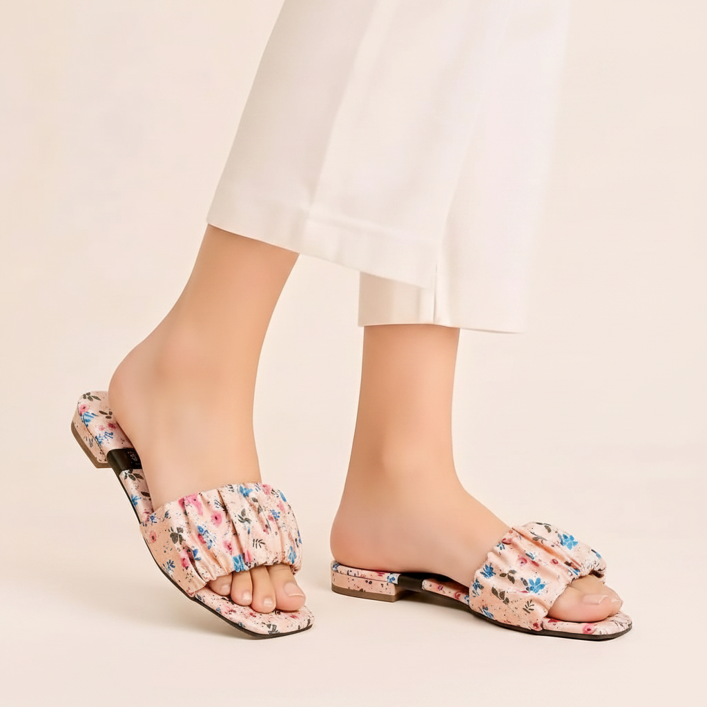 Pink floral sandals on feet - white background